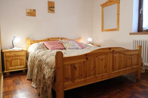 a bedroom with a wooden bed and a night stand at Appartamento Madiai in Canazei