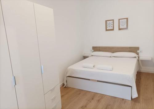 a white bedroom with a bed and white cabinets at NUEVO Apartamento Centro Lleida in Lleida