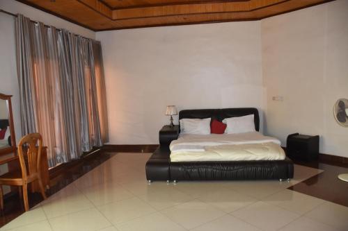 - une chambre avec un lit, une table et une chaise dans l'établissement Vincenzo trading, à Kigali