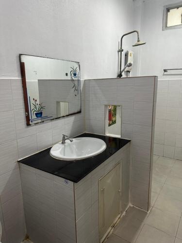 uma casa de banho com um lavatório e um espelho em โรงแรมราชิการีสอร์ท em Khon Kaen