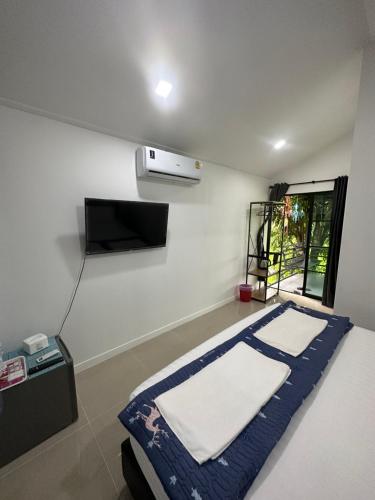 a room with a bed and a tv in it at โรงแรมราชิการีสอร์ท in Khon Kaen