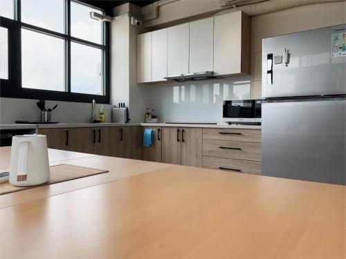 a kitchen with white appliances and a wooden counter top at 谷園酒店公寓Good Garden Apartment in Taichung