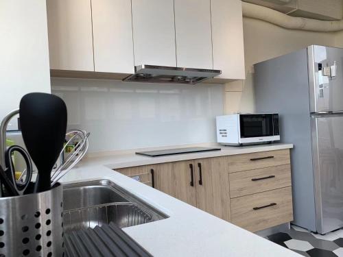 a kitchen with a sink and a microwave at 谷園酒店公寓Good Garden Apartment in Taichung