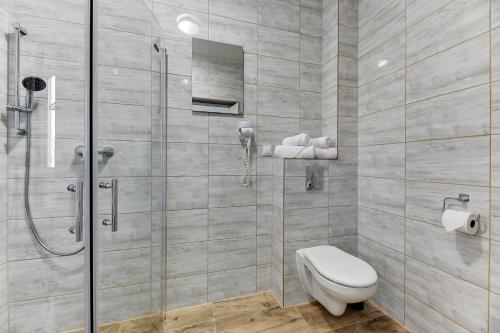 a bathroom with a toilet and a shower at Mile Gdansk Airport & Parking Długoterminowy in Gdańsk