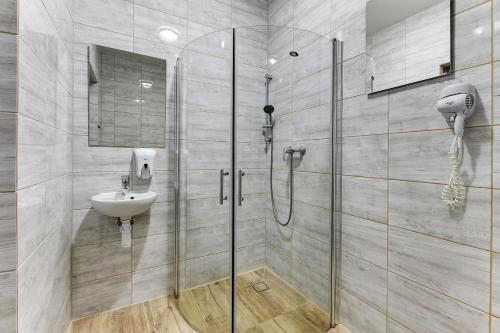 a bathroom with a shower and a sink at Mile Gdansk Airport & Parking Długoterminowy in Gdańsk