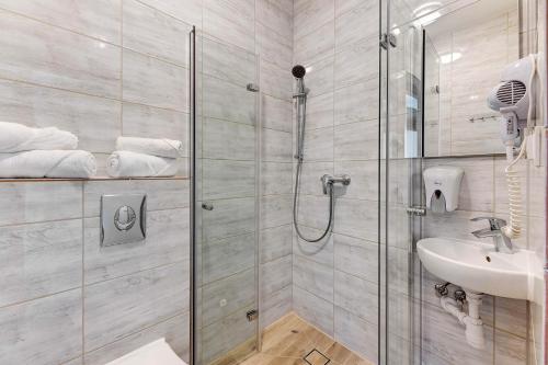 a bathroom with a shower and a sink at Mile Gdansk Airport in Gdańsk