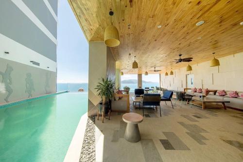 a living room with a pool and a table and chairs at JK.Boutique Oceanfront Panorama Residence in Nha Trang