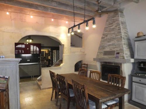 Il comprend une cuisine et une salle à manger avec une table et une cheminée. dans l'établissement Rosemonde, à Arles