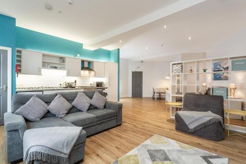 a living room with a couch and a kitchen at Walled City Apartments in Derry Londonderry