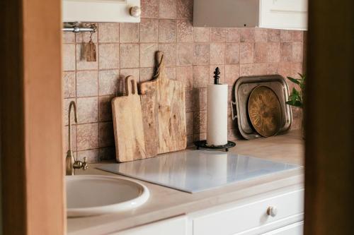 a kitchen counter with a sink and a cutting board at W Starym Dworku - unikatowy dom z ogrodem na wyłączność in Kazimierz Dolny