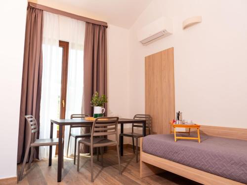 a room with a table and chairs and a bed at Appartamento Talamone - Santa Francesca in Talamone