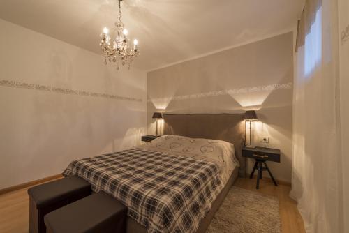 een kleine slaapkamer met een bed en een kroonluchter bij Apartment Sofia in Mühlbach