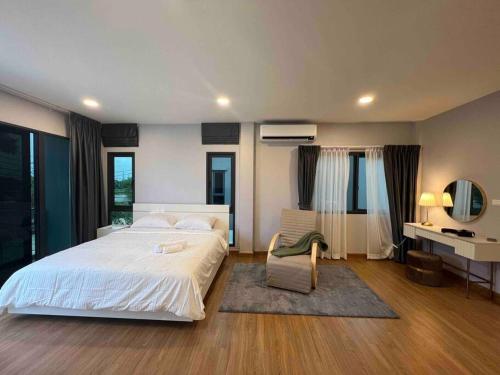 - une chambre avec un grand lit blanc et une chaise dans l'établissement Bangna 4bedroom new house luxurious discount now, à Bangkok