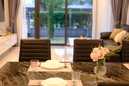 a dining room table with a vase of flowers on it at Bangna 4bedroom new house luxurious discount now in Bangkok