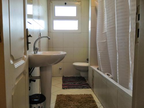 uma casa de banho com um lavatório, um WC e uma janela. em للسيدات Master bedroom for ladies only Sheik Zayed em Sheikh Zayed