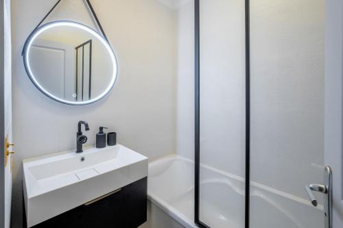 une salle de bain avec un lavabo blanc et un miroir dans l'établissement Le Musée - Appartement prestigieux & chic, à Montpellier