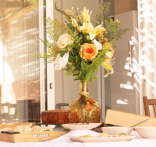 a vase filled with flowers on a table at Coral Boutique Suites in Albufeira