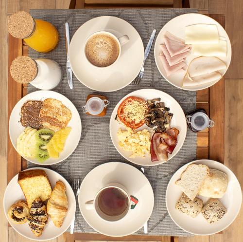 a table with plates of food and a cup of coffee at Coral Boutique Suites in Albufeira