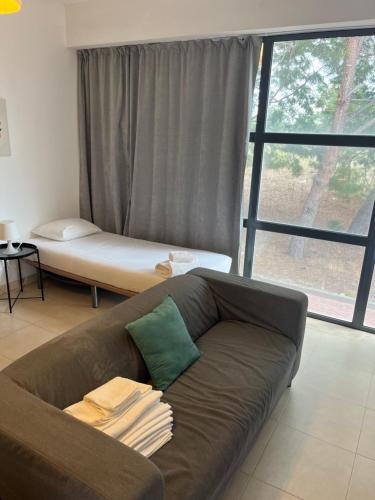 un sofá en una sala de estar con una gran ventana en Nice Resort Studio Holidays Family in Palmela, en Quinta do Anjo