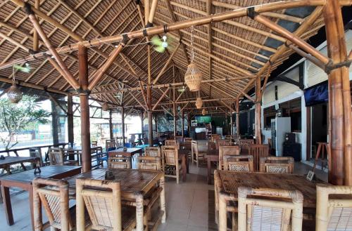 an empty restaurant with wooden tables and chairs at New Taman Sari Homestay in Pawenang