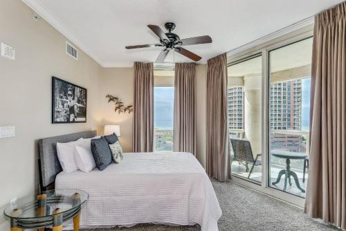 una camera con letto, ventilatore a soffitto e balcone di 2 Portofino 707 a Pensacola Beach