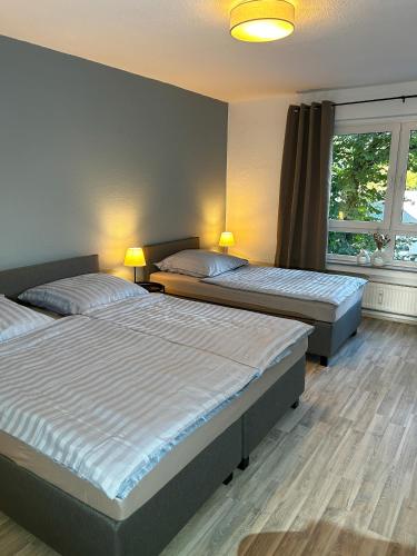 een slaapkamer met 2 bedden en een raam bij ERSTAY - bis zu 5 Personen I Balkon in Marl