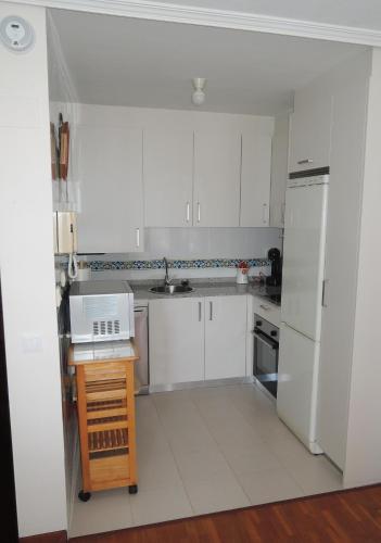 una cucina bianca con lavello e frigorifero di Apartamento con vistas, Mar de Salinas VUT3883AS a Salinas