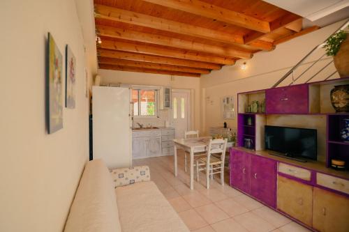 a kitchen and living room with purple cabinets and a table at Evgenias House Ancient Olympia - Happy Rentals in Olympia