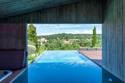 a large swimming pool in a building with a view at in Bulla, Country and Wellness - Turismo Rural in Seixo do Côa