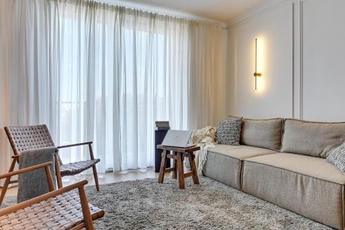 een woonkamer met een bank en een laptop op een tafel bij Angielska Grobla - City Center, Marina & Parking by Downtown Apartments in Gdańsk