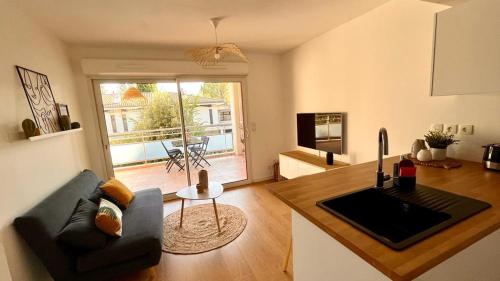エクス・アン・プロヴァンスにあるBel appartement au calme climatisé avec terrasseのキッチン、リビングルーム(ソファ、テーブル付)