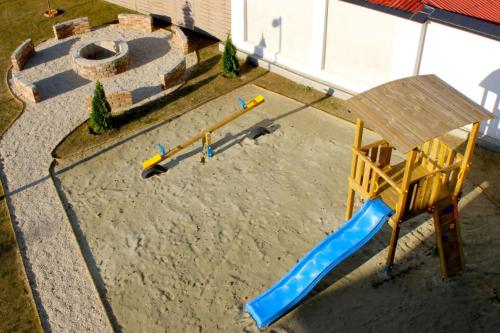 a playground with a slide in the sand at Zafír Apartman Sárvár in Sárvár
