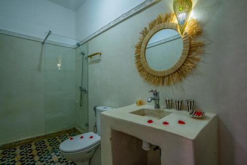 a bathroom with a sink and a toilet and a mirror at Riad HAFSSA & Spa in Marrakesh