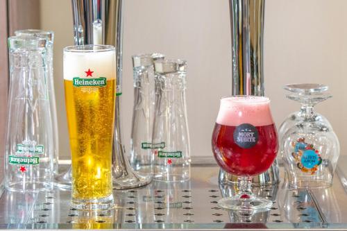 two glasses of beer sitting on top of a table at Szarvaskút Hotel in Zirc