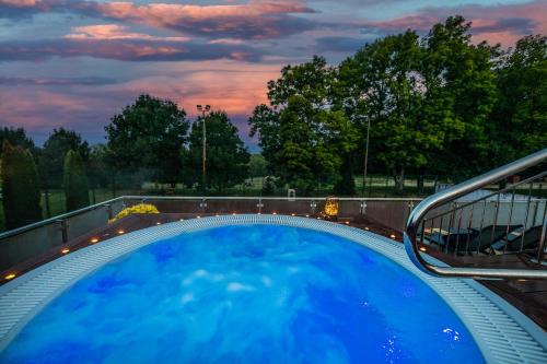 a plunge pool with a hot tub and a bench at Szarvaskút Hotel in Zirc