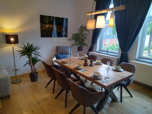uma sala de jantar com uma mesa de madeira e cadeiras em FeRo´s Ferienwohnung em Wernigerode