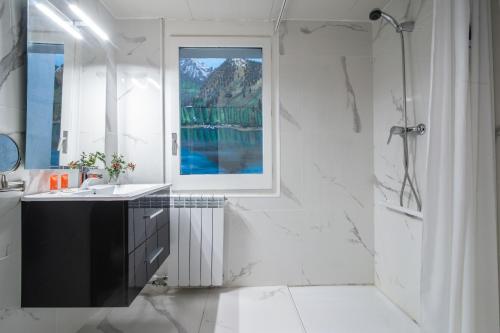 baño con lavabo, ducha y ventana en Hotel Austria by Pierre & Vacances en Soldeu