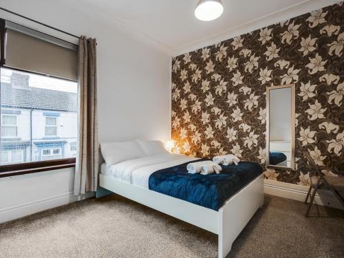 una camera da letto con un letto con un orsacchiotto su una coperta blu di Pass the Keys Anfield Cozy Home Free Parking Discounts a Liverpool