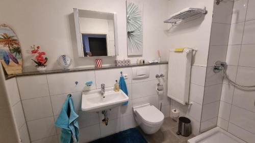 a bathroom with a sink and a toilet and a mirror at Ferienzimmer bei Thomas in Ulm