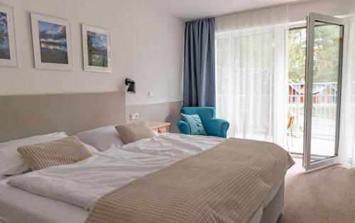 ein Schlafzimmer mit einem Bett und einem großen Fenster in der Unterkunft Resort-Restaurant Stilec in Kamenný Újezd