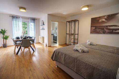 a bedroom with a bed and a dining room at ImmoStay #2 -Moderne Wohnung mit zwei Balkonen, WLAN & Parkmöglichkeit in Stuhr