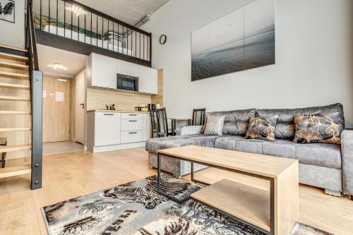 a living room with a couch and a table at RentPlanet - Apartamenty Zarembowicza II in Wrocław