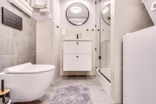 a bathroom with a toilet and a sink and a mirror at RentPlanet - Apartamenty Zarembowicza II in Wrocław