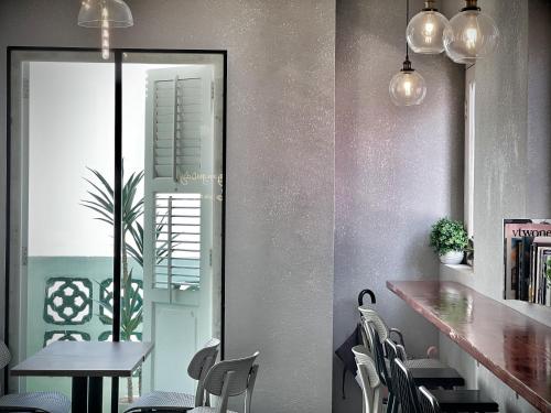 a dining room with chairs and a table and a mirror at Rest Chinatown Hotel in Singapore