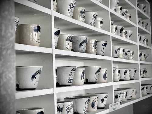 a shelf filled with white cups and bowls at Rest Chinatown Hotel in Singapore