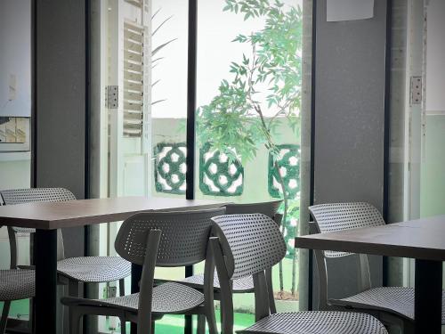 a room with tables and chairs and a window at Rest Chinatown Hotel in Singapore