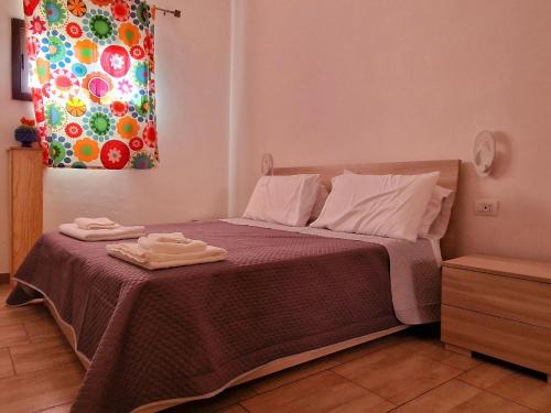 um quarto com uma cama com duas toalhas em Casa Vacanze Margherita em Caltagirone