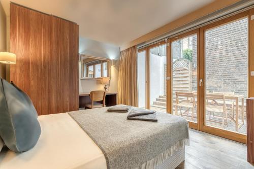 a hotel room with a bed and a large window at Grosvenor Mayfair in London