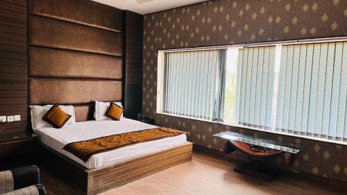 um pequeno quarto com uma cama e uma janela em Hotel Riya Palace By Standards em Haldwani