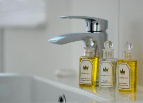 two bottles of soap sitting on a bathroom sink at Lovely 2-Bed Apartment in Stanford-le-Hope in Stanford-le-Hope